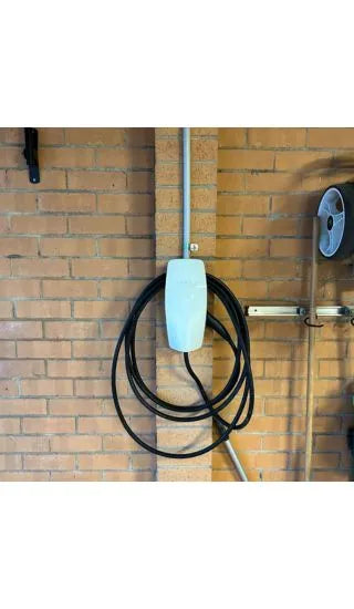 White tesla ev charger installed on a brick wall