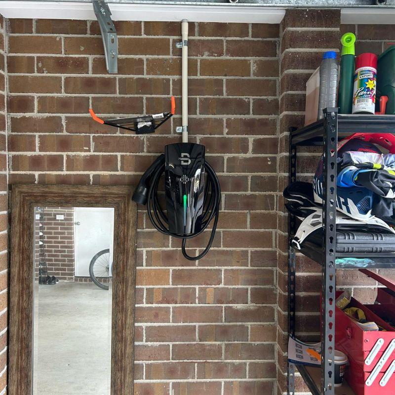 black Beny EV charger on a brick wall.