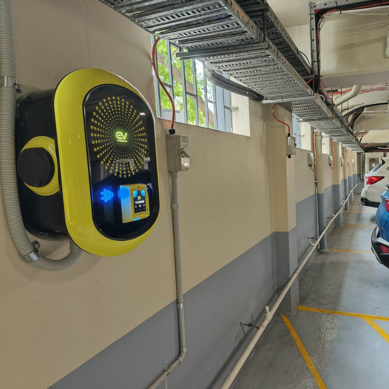 Electric vehicle charging station with digital display in a parking garage.