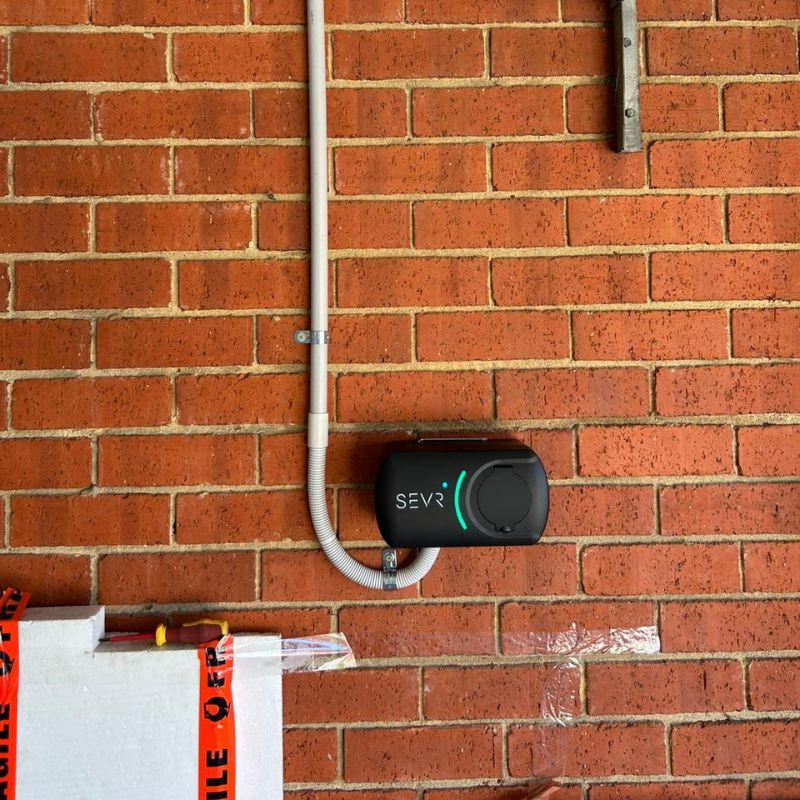 SEVR EV charger mounted on a brick wall