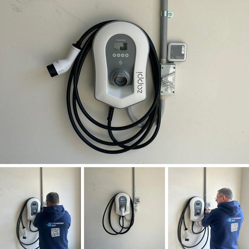 Zappi electric vehicle charging station mounted on a wall with a technician inspecting it.