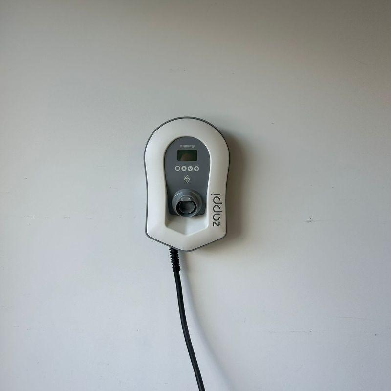 Zappi electric vehicle charging station mounted on a white wall.