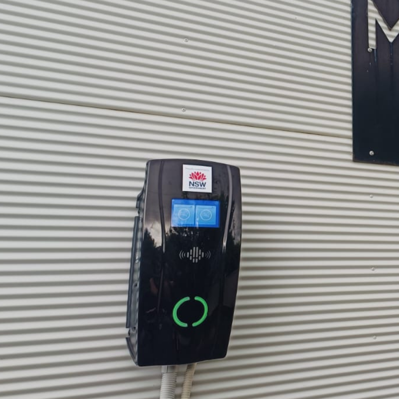 Black EV charging device on a corrugated metal wall