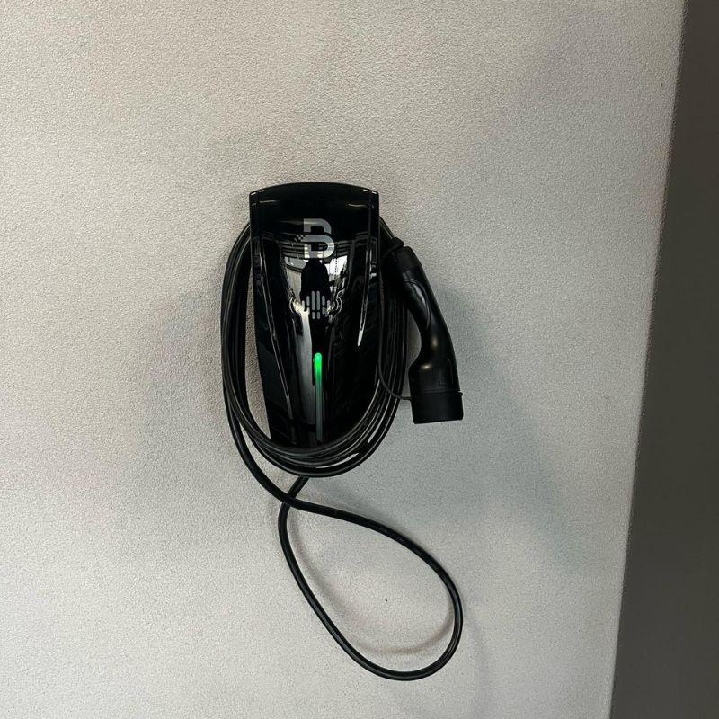Black Beny electric vehicle charging attached on a wall