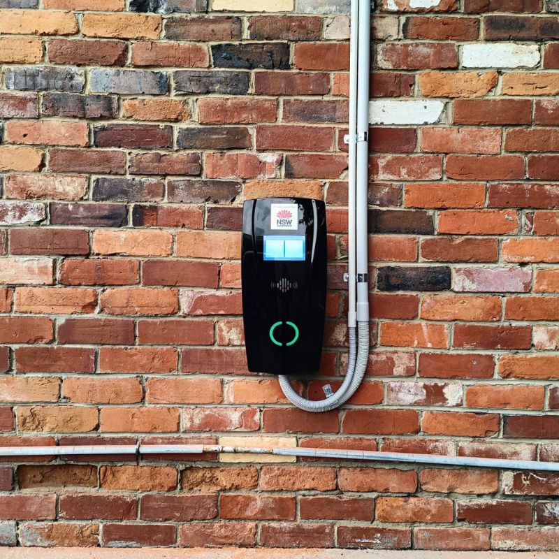 Electric vehicle charging station mounted on a brick wall