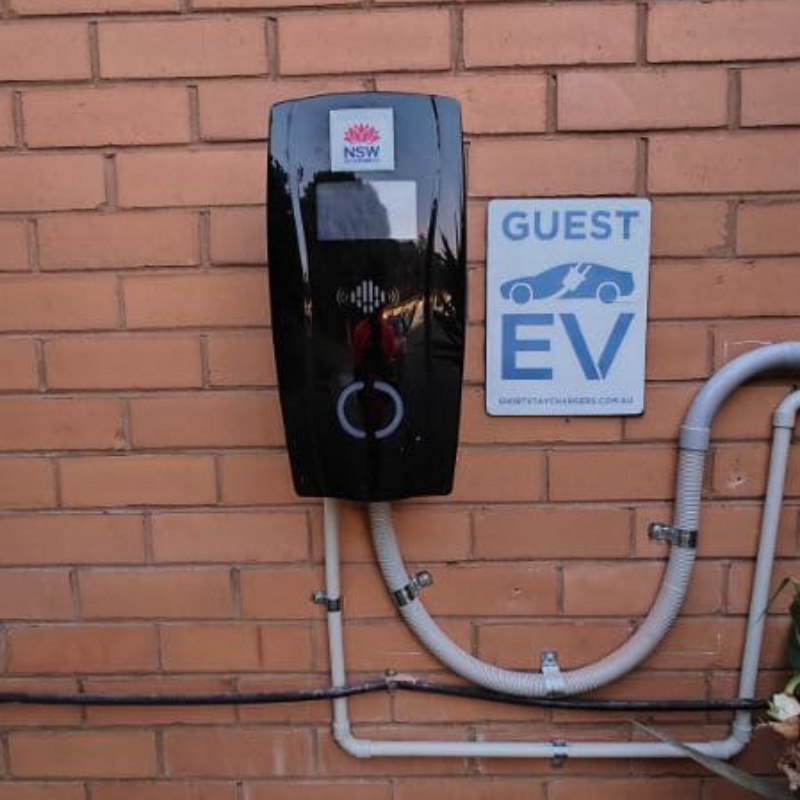 Electric vehicle charging station mounted on a brick wall
