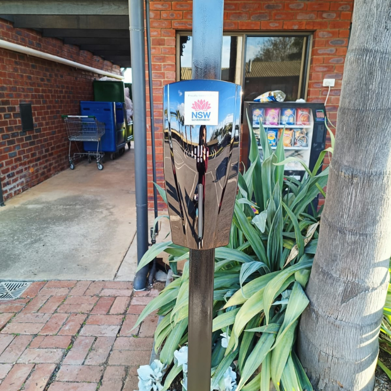 black ev charging unit installed on black post