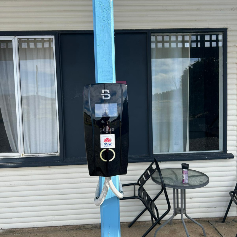 Black EV charging device installed on a blue pole