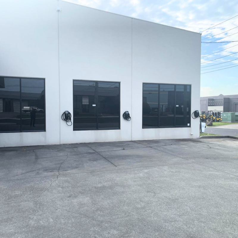 Three black EV charging device installed on a white building