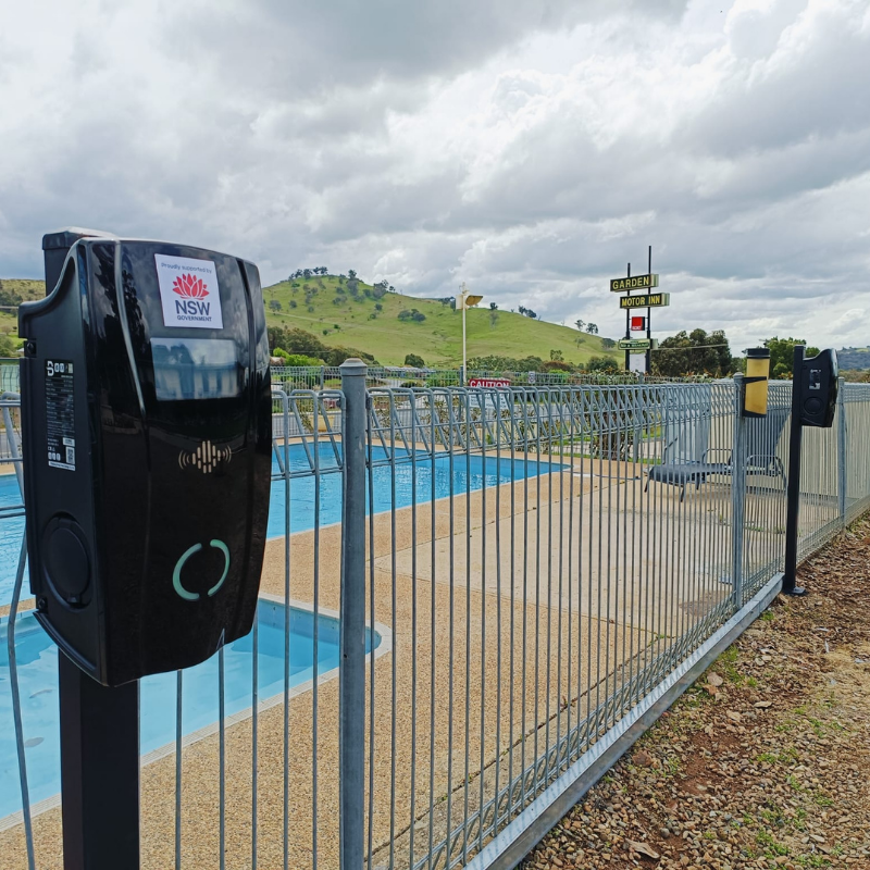Black EV charging device near a pool area 