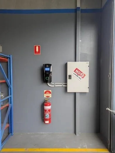 black EV charging device mounted on a grey wall