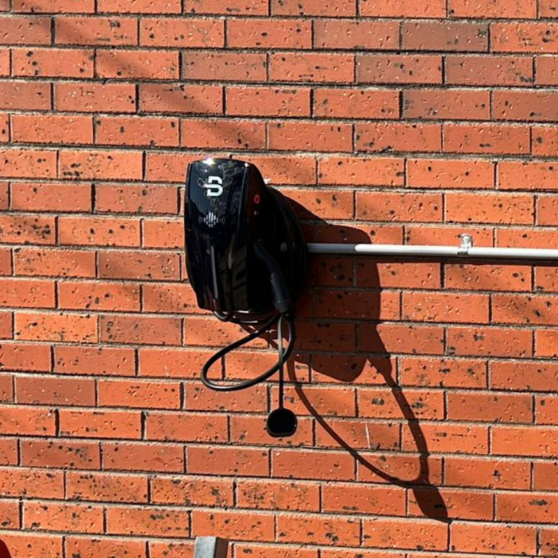 Black ev charger mounted on a brick wall