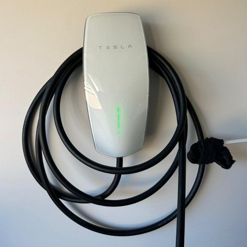 White Tesla wall charger mounted on garage wall