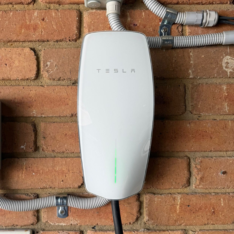 Tesla Wall Connector mounted on a brick wall