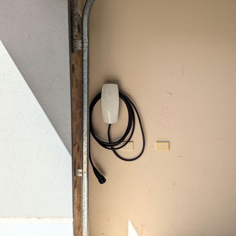 white tesla wall charger mounted on a wall