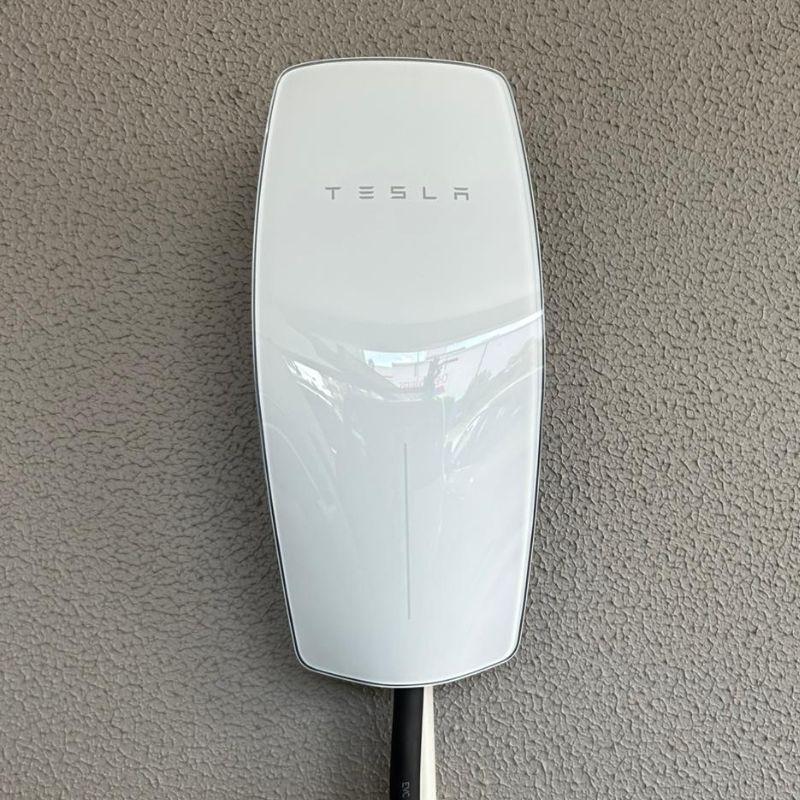 Tesla Gen 3 electric vehicle charging station on a gray wall