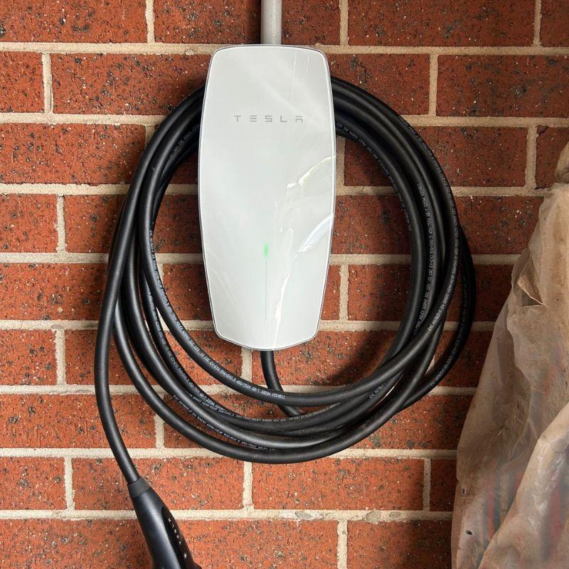 Tesla electric vehicle charging station mounted on a brick wall