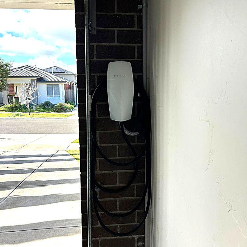 Tesla wall connector mounted on a brick wall 