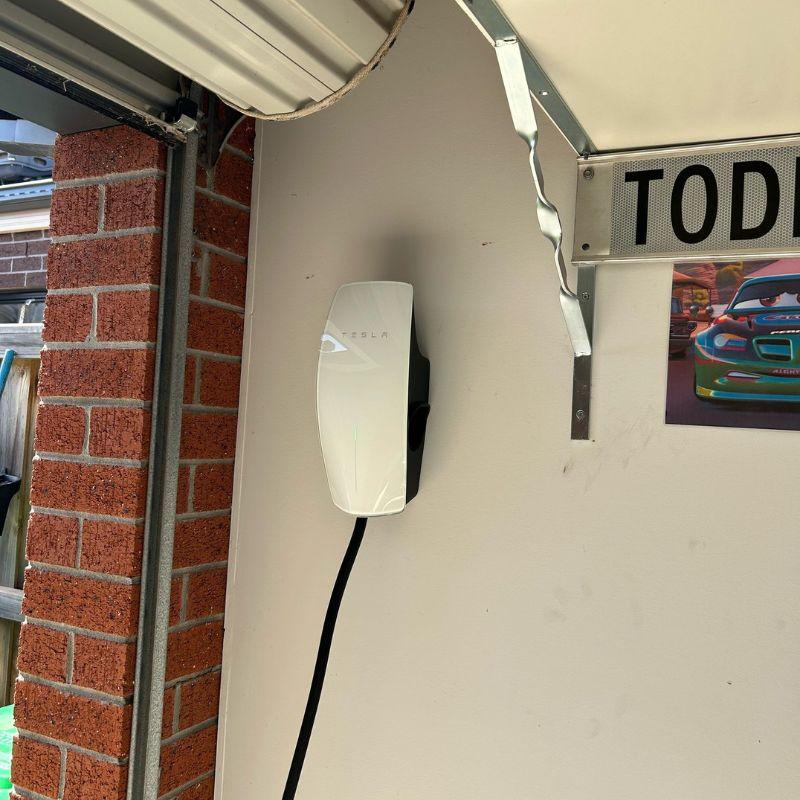 white Tesla wall connector attached to the wall