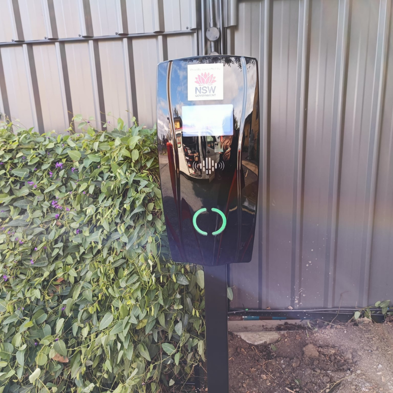 black ev charging unit installed on a black pole