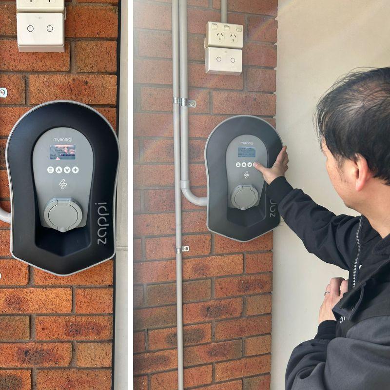 black zappi electric vehicle charging station on a brick wall.